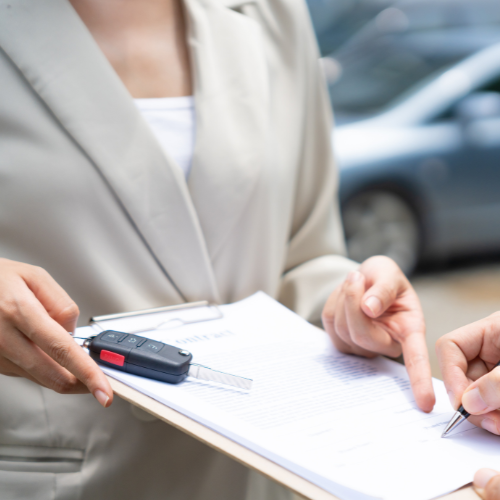 Title loan refinance contract review Loan agent reviewing a title loan refinance contract with a car key