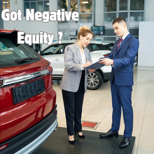 Two people striking a deal for a red colored vehicle.